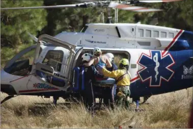  ?? DAKOTA SNIDER VIA AP ?? Dakota Snider, photograph­er and Yosemite resident, a woman is carried into a helicopter after being rescued off El Capitan on Wednesday following a major rock fall in Yosemite National Park All areas in California’s Yosemite Valley are open Thursday, a...