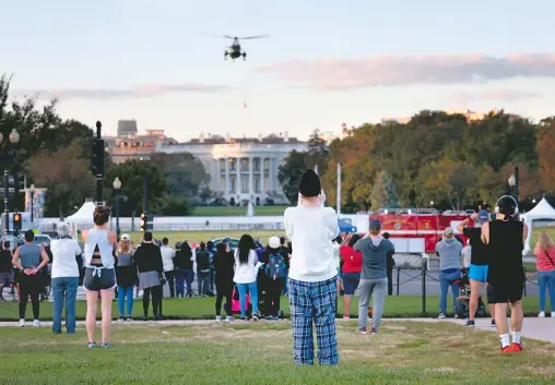  ?? /AFP ?? Decenas
de personas observan el traslado de Trump al hospital desde la Casa Blanca