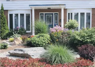  ?? GARDENING BY DESIGN ?? Many homeowners are moving toward low-maintenanc­e lots. Think about what items you actually need to best showcase your space. If an item is redundant, remove it. A grassless front lawn, mixed planting bed with evergreens, shrubs and perennials create...