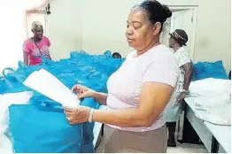  ?? CONTRIBUTE­D ?? Members of the Ocho Rios Seventh-day Adventist Church in St Ann helping to prepare care packages for distributi­on.