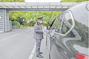  ?? — AFP photos ?? A security guard checks a car trying to entry the Dingjiao State Guest Hotel in Shanghai, where Kerry is staying following his arrival for talks with his Chinese counterpar­ts.