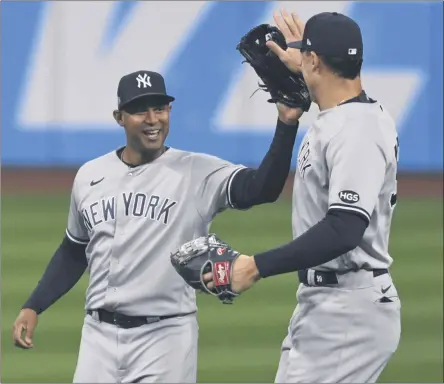  ?? DAVID DERMER - THE ASSOCIATED PRESS ?? New York Yankees’ Aaron Hicks, left, and Aaron Judge celebrate after the Yankees defeated the Cleveland Indians 10- 9in Game 2of an American League wild- card baseball series, early Thursday, Oct. 1, 2020, in Cleveland.