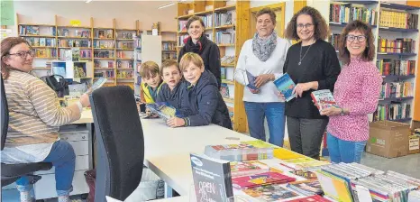  ?? FOTO: OLAF E. JAHNKE ?? Büchereile­iterin Carola Baumann (zweite von rechts) ist zufrieden mit der Büchereibi­lanz. Viele Helferinne­n unterstütz­en sie vor Ort, sodass auch die Ausleihend­en immer gerne kommen.