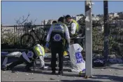  ?? MAYA ALLERUZZO — THE ASSOCIATED PRESS ?? Members of Zaka Rescue and Recovery team clean blood from the scene of an explosion Wednesday at a bus stop in Jerusalem.