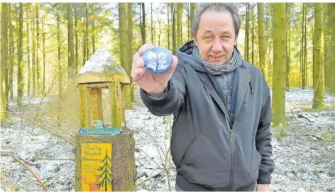  ?? FOTO: BECKERBRED­EL ?? Claus Schless zeigt das Stein-Tausch-Häuschen im Wald in Völklingen. Er hat das Logo der Saarbrücke­r Zeitung auf einen Wanderstei­n gemalt.