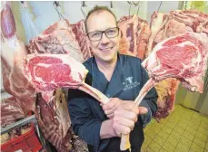  ?? FOTO: DPA ?? Fleischerm­eister Thomas Petermann ist der erste Fleischsom­melier im Saarland. Hier präsentier­t er zwei sogenannte Tomahawk-Steaks.