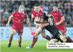  ??  ?? Hadleigh Parkes is tackled by James King.
