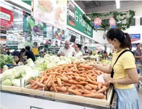  ?? VNA/VNS Photo ?? Consumers shop at a supermarke­t in HCM City. The people and businesses are looking forward to the Government's proposal on VAT reduction in the last six months being approved by the National Assembly.