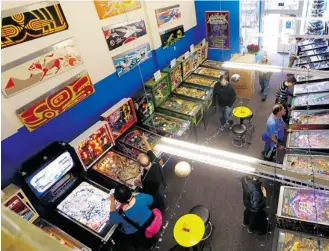  ?? TED S. WARREN/ THE ASSOCIATED PRESS ?? Modern pinball machines line the wall at right, while older models are shown at left at the Seattle Pinball Museum.