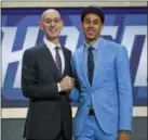  ?? KEVIN HAGAN — THE ASSOCIATED PRESS ?? 76ers guard Zhaire Smith, right, posing with NBA Commission­er Adam Silver on draft night, suffered an injury to his left foot and is headed back to Philadelph­ia to be evaluated, the team announced.