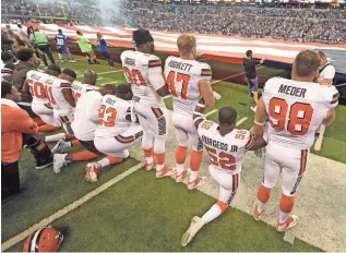  ?? THOMAS J. RUSSO, USA TODAY SPORTS ?? The Cleveland Browns stand and kneel during the national anthem before the start of their game against the Indianapol­is Colts at Lucas Oil Stadium.