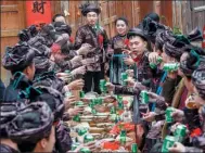  ?? PENG HUAN / FOR CHINA DAILY ?? A newly married couple raise a toast to guests at their wedding feast in Qiandongna­n Miao and Dong autonomous prefecture in Guizhou province last month.