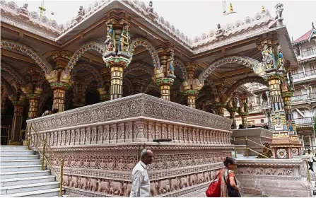  ??  ?? Ornate site: Devotees at the nearly 200-year-old Swaminaray­an Kalupur Temple in Ahmedabad. The 600-year-old mosques, traditiona­l markets and ornate homes of Ahmedabad have been named India’s first Unesco city. — AFP