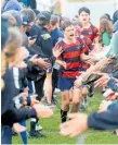  ?? ?? Captain Teina Williams leads out the Te Puke Intermedia­te School’s rugby sevens team for the AIMS Games final.