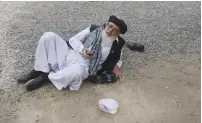  ?? (Reuters) ?? A MAN LIES STUNNED on the ground after a suicide blast in Kabul yesterday.
