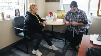  ?? LEAH HENNEL ?? Deb Runnalls, Mustard Seed housing director, left, with client Les H. Runnalls suffers from a rare condition that’s destroying the pupils of both eyes, but that is not stopping her from continuing her work.