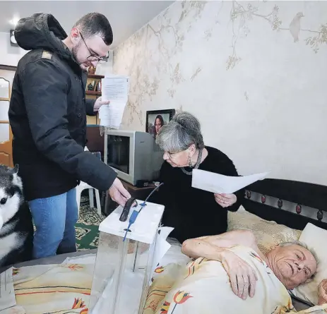  ?? EFE ?? Un funcionari­o electoral recoge el voto de un hombre enfermo y su mujer ayer en Moscú