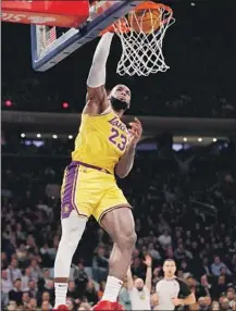  ?? Kathy Willens Associated Press ?? THE LAKERS’ LeBron James dunks for two of his 21 points against the Knicks. He also had five assists and six rebounds.