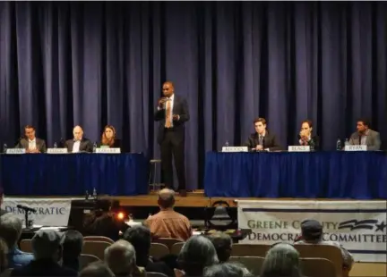  ?? PHOTO BY WILLIAM J. KEMBLE ?? Antonio Delgado, standing, speaks during the Thursday evening forum at Saugerties High School. Seated, from left, are fellow Democratic candidates Brian Flynn, David Clegg, Erin Collier, Gareth Rhodes, Jeff Beals and Patrick Ryan.