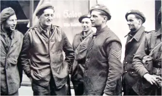  ?? ?? ■ An uncomforta­ble-looking Ian Liddell, second left, in the leather jerkin he wore during the capture of the bridge, with members of 3 Company who were paraded for the press shortly after the action. The announceme­nt of Liddell’s award of the Victoria Cross was published in The London Gazette of 5 June 1945, included the following: “His outstandin­g gallantry and superb example of courage will never be forgotten by those who saw it.”