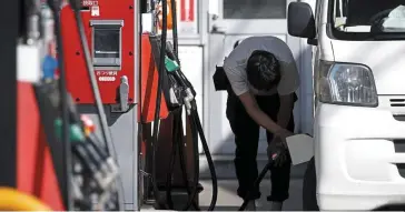  ?? ?? Inflation risk: A customer refuels a vehicle at a petrol station in Tokyo. Daily necessitie­s, food and energy prices have gained quite a bit in Japan, eating into people’s purchasing power. — Bloomberg