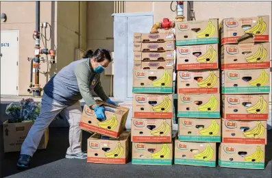  ?? ANDRI TAMBUNAN THE NEW YORK TIMES ?? Vue Vang collects donated food from a Trader Joe's in Fresno, where, under a new law, grocery stores are required to donate “the maximum amount of edible food that would otherwise be disposed.”