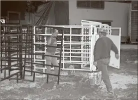  ?? Doug Walker ?? Ethan Ray (left) and Ross Lowry help set up the Forum River Center for the annual Three Rivers Invitation­al Bull Riding event Friday and Saturday nights.