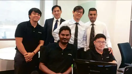  ??  ?? Lim (standing, second from right) with Ng (standing, second from left) and the team that won Imperium Solutions an Enterprise 50 Award.