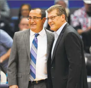  ?? Jessica Hill / AP ?? South Florida's Jose Fernandez, left, and UConn’s Geno Auriemma, right, pose before a game on Jan. 10 in Hartford.