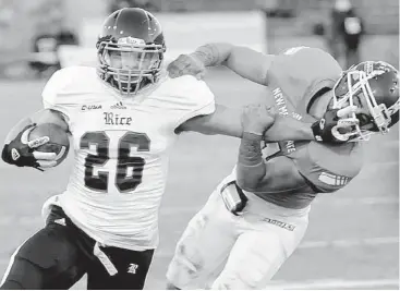  ?? Robin Zielinski / Associated Press ?? Rice running back Turner Petersen, left, dishes out some punishment to New Mexico State’s Davis Cazare.