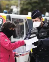  ??  ?? Un policier vérifie une attestatio­n de déplacemen­t, à Toulouse, le 8 avril.