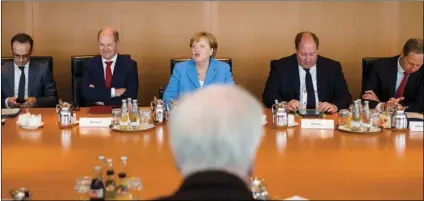  ??  ?? German Interior Minister Horst Seehofer (front) sits on the opposite of German German Chancellor Angela Merkel (center back ground) prior to the weekly cabinet meeting of the German government at the chanceller­y in Berlin, on Wednesday. AP PHOTO/MARKUS...