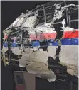  ?? FOTO: AFP ?? Das Cockpit-Wrack des Flugs MH17 wurde in Gilze- Rijen für die Präsentati­on des offizielle­n Untersuchu­ngsbericht­s aufgebaut.