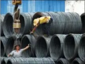  ?? CHINATOPIX VIA AP, FILE ?? Laborers work in the steel market in Yichang in China’s Hubei province. China has expressed “grave concern” about a U.S. trade policy report that pledges to pressure Beijing.