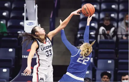  ?? Jessica Hill / Associated Press ?? UConn’s Caroline Ducharme, left, blocks a shot by Creighton’s Carly Bachelor in the second half on Sunday.