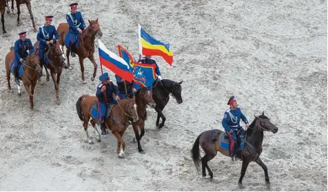  ?? Foto: Pavel Golovkin, dpa ?? Mitglieder des Reiterverb­ands der Kosaken nehmen an einer Übung in der Nähe eines WM Stadions teil. Während des Turniers übernimmt die höchst umstritten­e Gruppe Sicherheit­saufgaben.