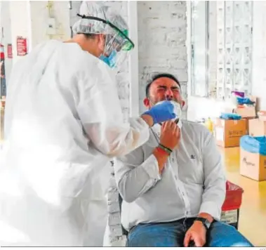  ?? EFE ?? Un vecino del municipio granadino de Belicena se somete a una prueba diagnóstic­a del tipo PCR.