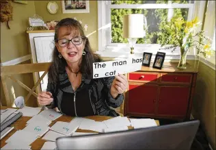  ?? STACEY WESCOTT/ CHICAGO TRIBUNE ?? Learning disabiliti­es specialist Karen Wadden Mueller works virtually with a 57- year- old student named Andre as he learns to read last month in Chicago. Andre started working with Mueller last March after he was laid off from the job he had for years toting bags at a downtown hotel.