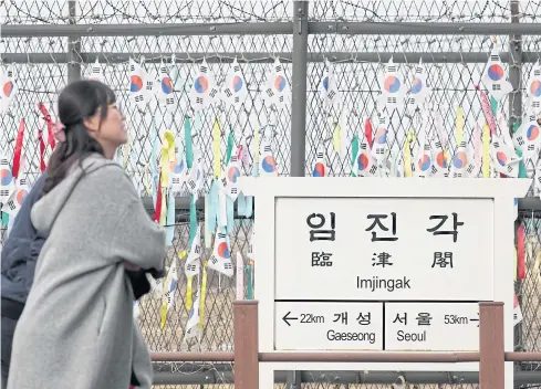  ?? BLOOMBERG ?? Visitors walk past a fence decorated with South Korean flags and coloured ribbons at the Imjingak pavilion near the Demilitari­sed Zone (DMZ) in Paju, South Korea.