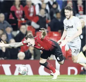  ?? AP ?? Manchester United’s Phil Jones (left) falls after a tackle by Derby County’s David Nugent during the English League Cup, third round match in Manchester, England yesterday.