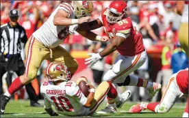  ?? JOHN SLEEZER/TRIBUNE NEWS SERVICE ?? San Francisco 49ers quarterbac­k Jimmy Garoppolo goes down after being tripped by by Kansas City Chiefs defensive end Allen Bailey as defensive tackle Chris Jones comes in to make sure Garoppolo is down on Sunday in Kansas City, Mo.