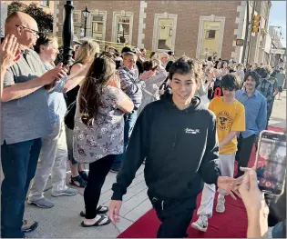  ?? NEWS PHOTO ANNA SMITH ?? Young members of the Medicine Hat Skateboard­ers Associatio­n walk down the red carpet past a cheering crowd on Thursday evening at the historic Monarch Theatre.