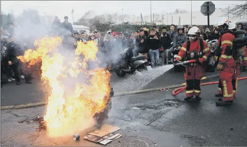  ??  ?? Firefighte­rs tackle a burning rubbish bin outside a school in Bayonne, south west France yesterday. Protesting students were disrupting schools and universiti­es.