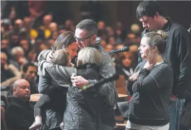  ?? Photos by Helen H. Richardson, The Denver Post ?? Gracie Parrish, holding her daughter Evie, receives emotional hugs from friends during a memorial and candleligh­t vigil in memory of her husband, Douglas County sheriff ’s Deputy Zackari Parrish, at Mission Hills Church in Littleton on Monday night....