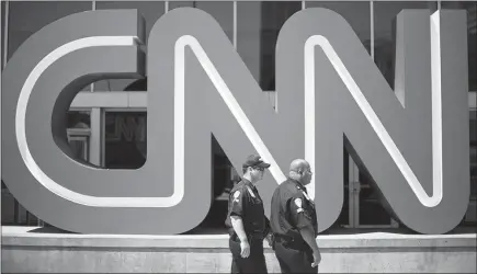  ?? DAVID GOLDMAN / AP FILE (2014) ?? Security guards walk past the entrance to CNN headquarte­rs in Atlanta. Created with much fanfare, CNN’S investigat­ive unit was reshaped and its focus narrowed in the wake of a story that led to a much-discussed retraction and an apology.