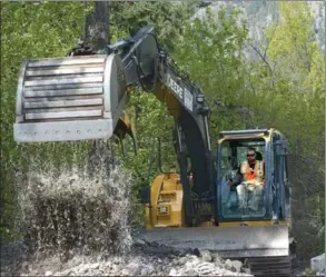  ?? GARY NYLANDER/Westside Weekly ?? An excavator operator removes debris from McDougall Creek where it crosses Shannon Lake Road in West Kelowna on Sunday.