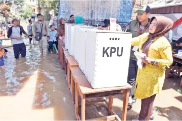  ?? — AFP photo ?? People vote at a flooded polling station during Indonesia’s general election in Bandung.