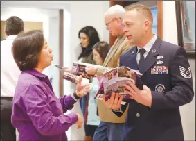  ?? NWA Democrat-Gazette/DAVID GOTTSCHALK ?? Chung Tan (from left), director of economic developmen­t with Fayettevil­le’s Chamber of Commerce, speaks Friday to Tech. Sgt. Brad Cargill with the Air National Guard following the unveiling of the new workforce book A Calling at a news conference at the chamber.