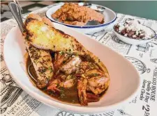  ?? Photos by J.C. Reid / Contributo­r ?? The BBQ Shrimp at Gatlin’s Fins & Feathers comes with long strips of garlic toast to soak up the sauce.