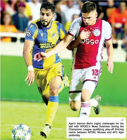  ?? AP ?? Ajax’s Razvan Marin (right) challenges for the ball with APOEL’s Musa Suleiman during the Champions League qualifying play-off first-leg match between APOEL Nicosia and AFC Ajax yesterday.